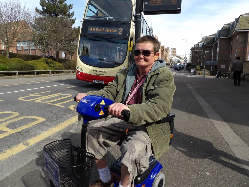 woman on scooter waiting for a bus