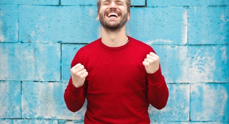 Man in red jumper looking very happy